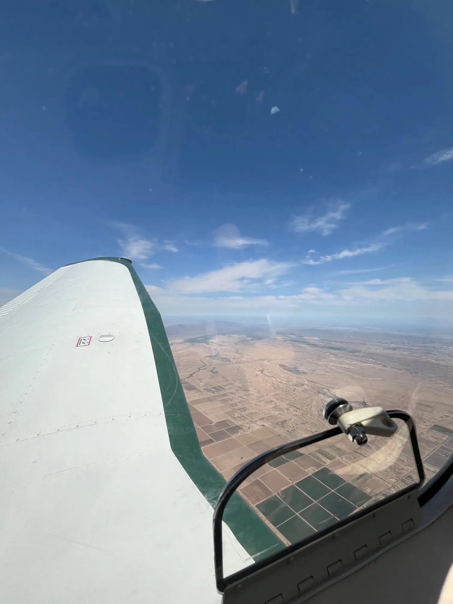 Farm fields and desert far below the wing on a clear day